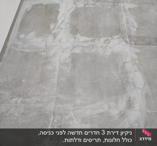 רצפה עם סימני ניקוי לבנים על אריחים אפורים